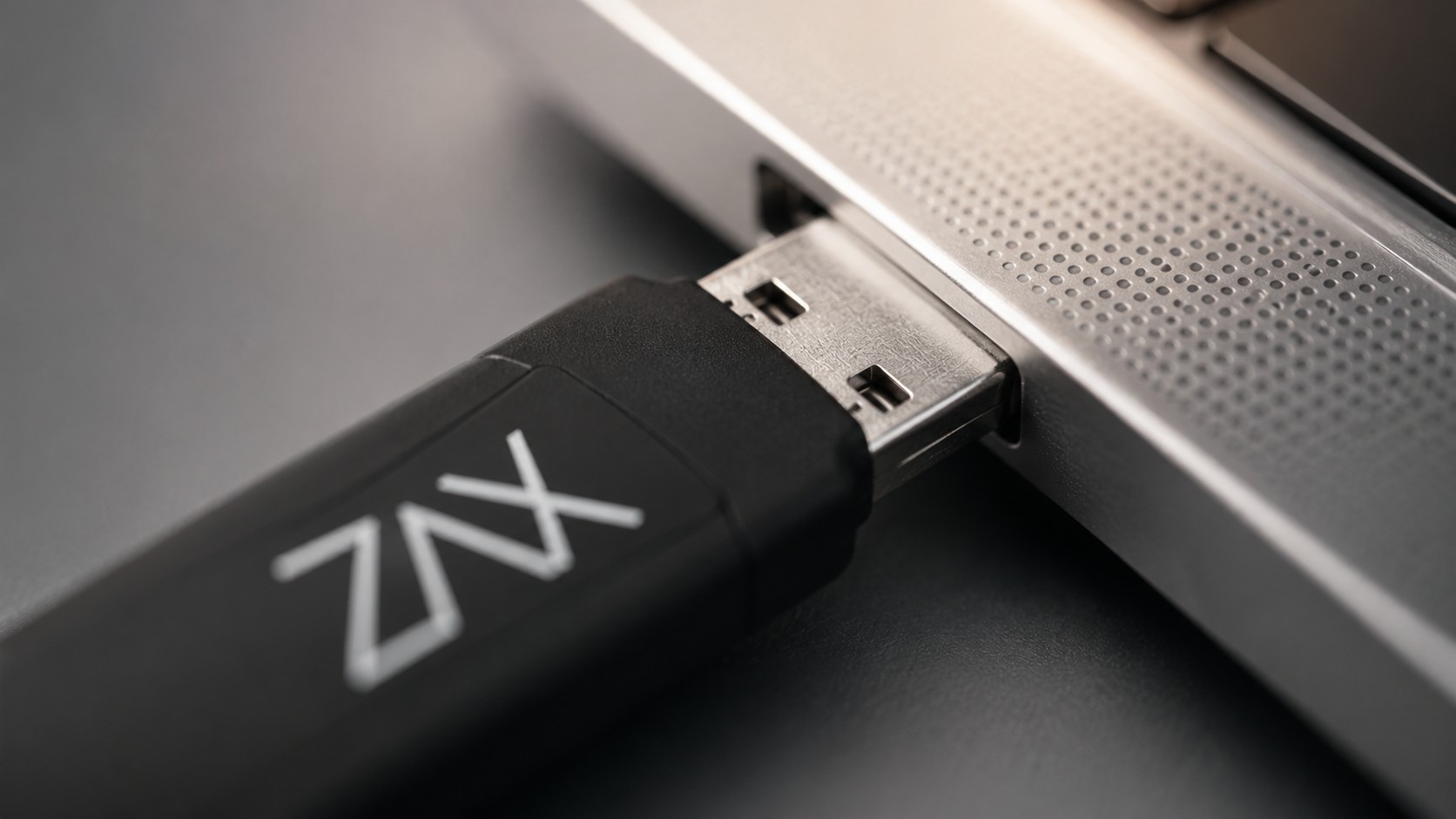 Zax Stick podłączany do portu USB w MacBooku — emulacja klawiatury